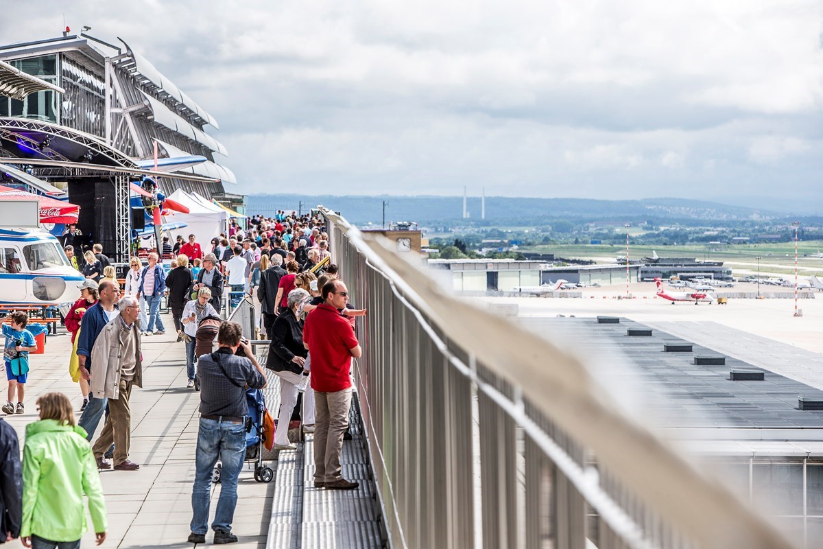 Menschen beobachten das Vorfeld von der Besucherterrasse aus