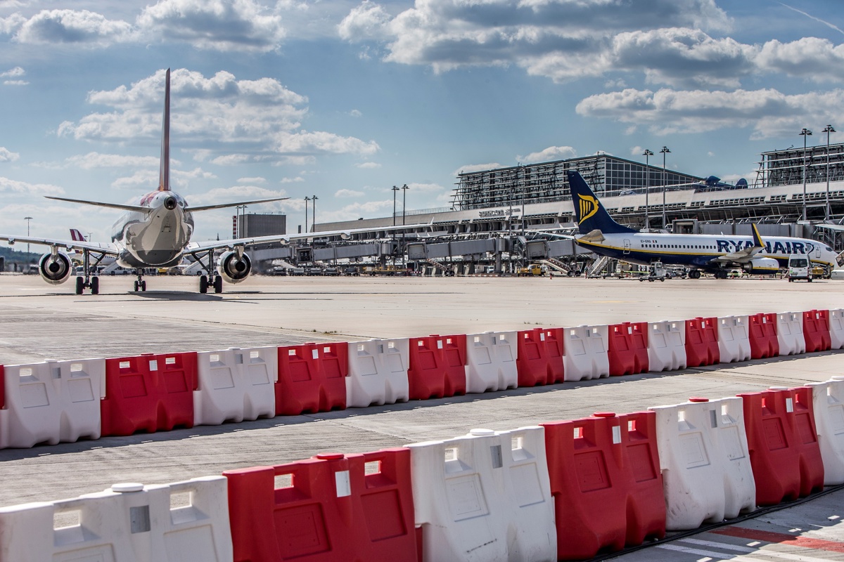 Baustellenabsperrung auf dem Vorfeld, dahinter Flugzeuge 