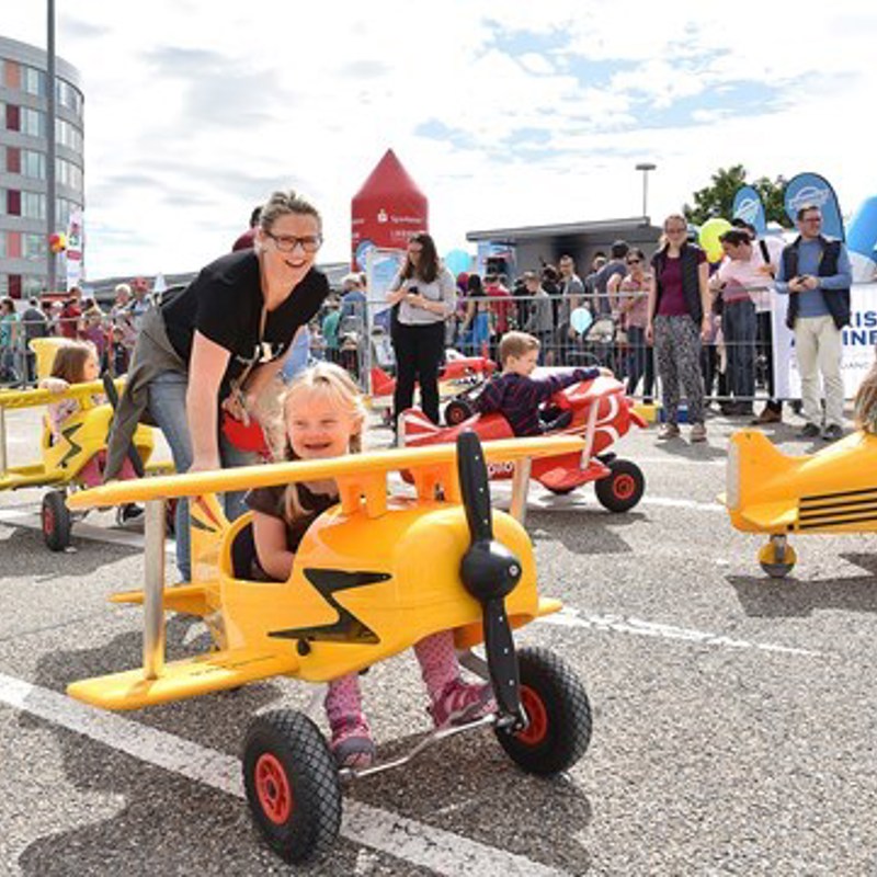 Kinder fahren mit Spielflugzeugen