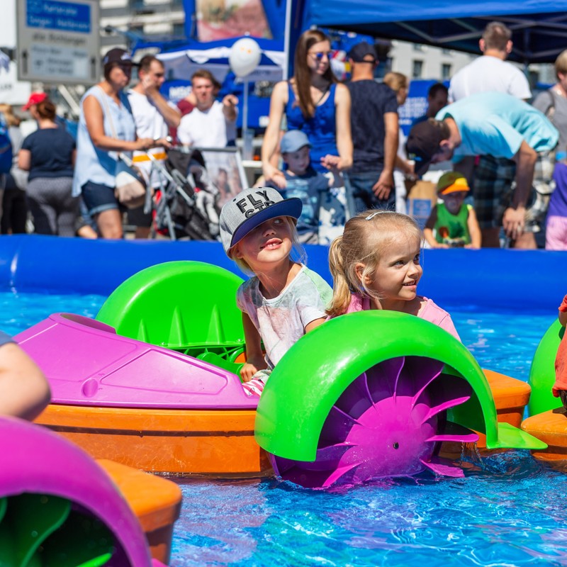 Kinder fahren mit Tretbooten im Pool