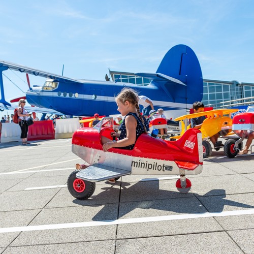 Kinder fahren mit Miniflugzeugen auf der Besucherterrasse