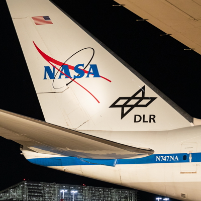 Heck des Forschungsflugzeuges bei Nacht, im Hintergrund das Terminal