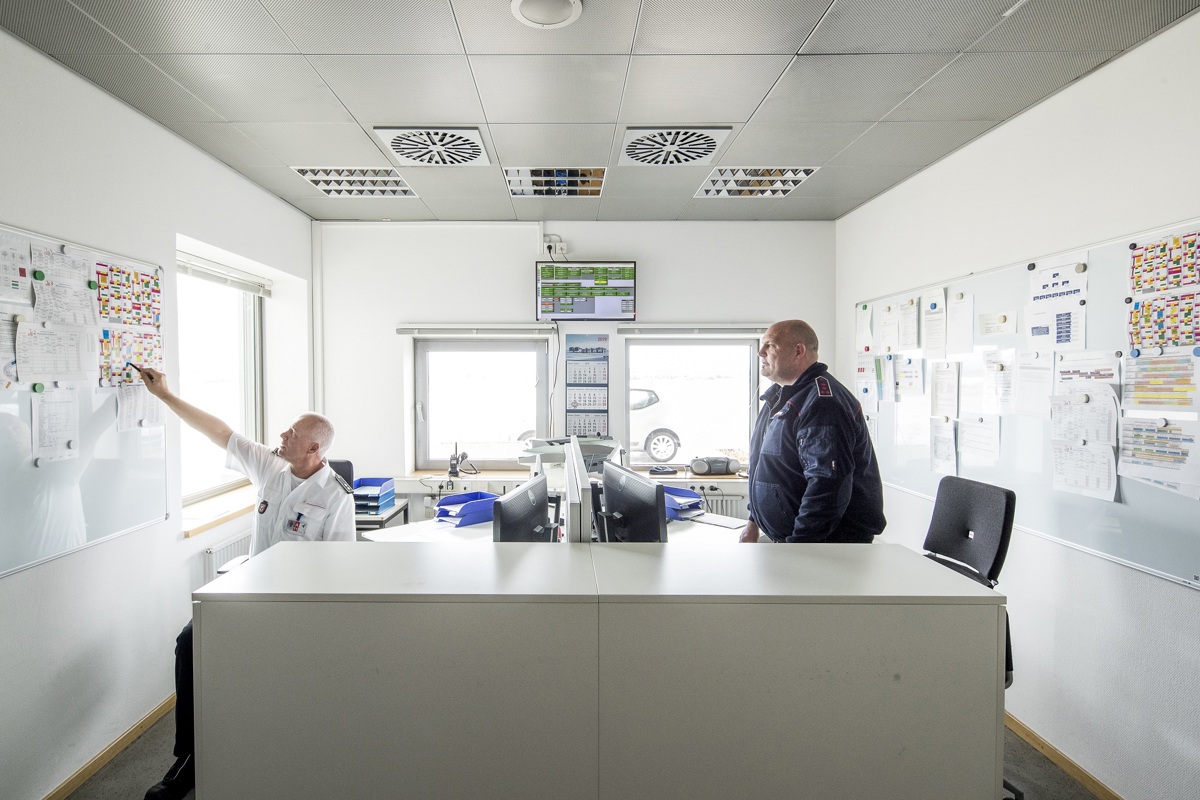 Zwei Mitarbeiter im Büro besprechen Pläne an der Wand