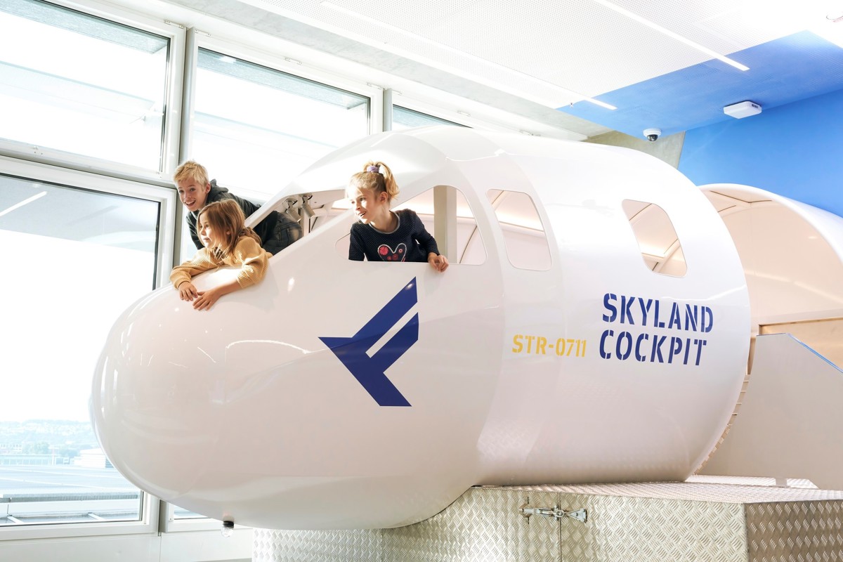 Kinder spielen im Modell eines Cockpits im SkyLand am Flughafen Stuttgart