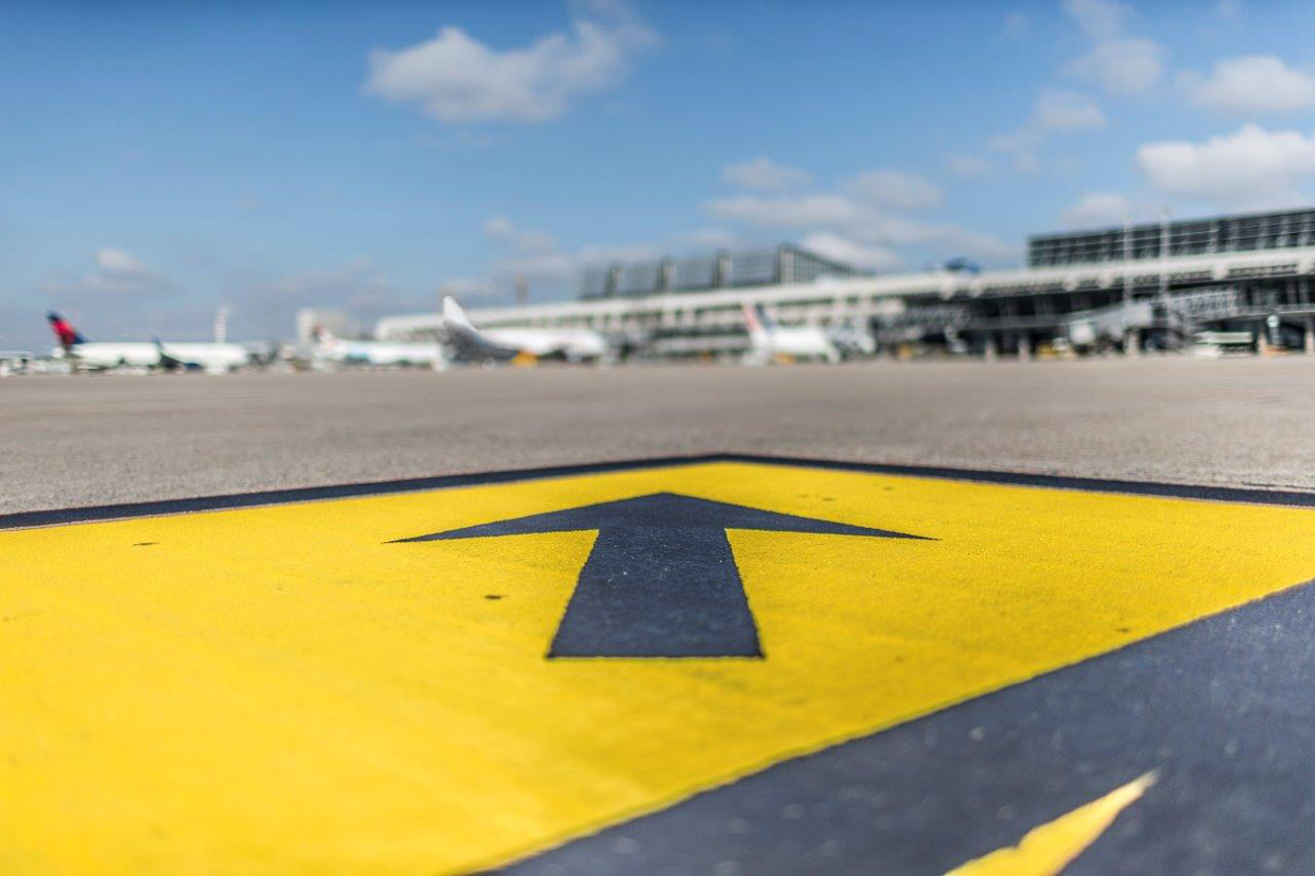 Pfeil auf dem Vorfeld vom Flughafen Stuttgart zeigt auf Flugzeuge und Terminal